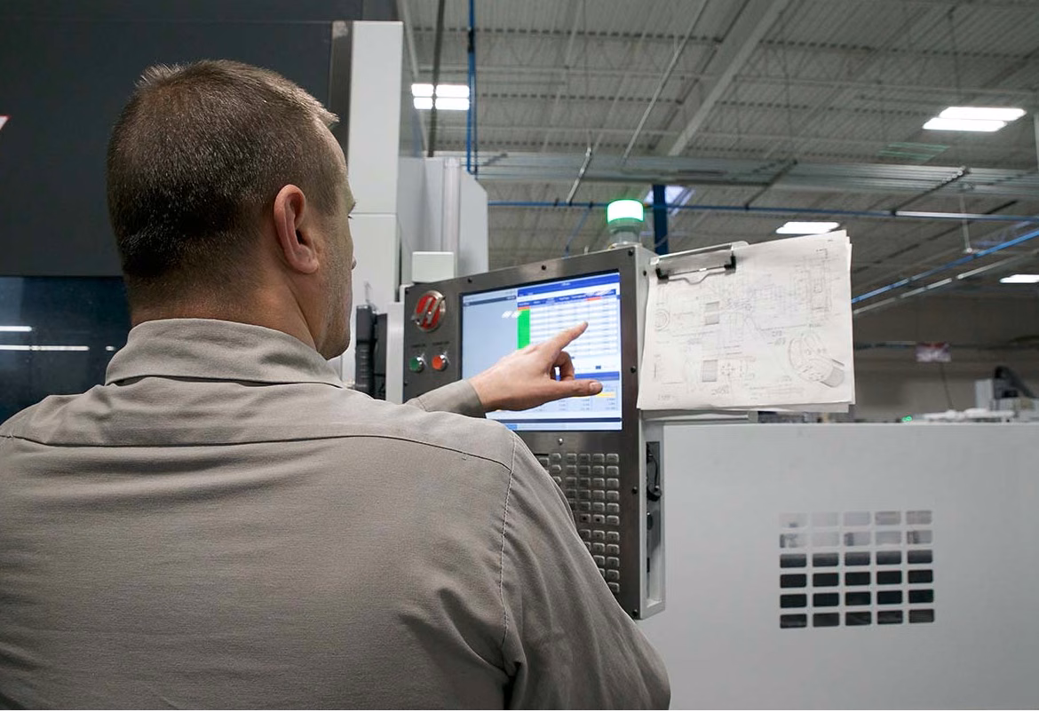 Employee operating Haas machine controls